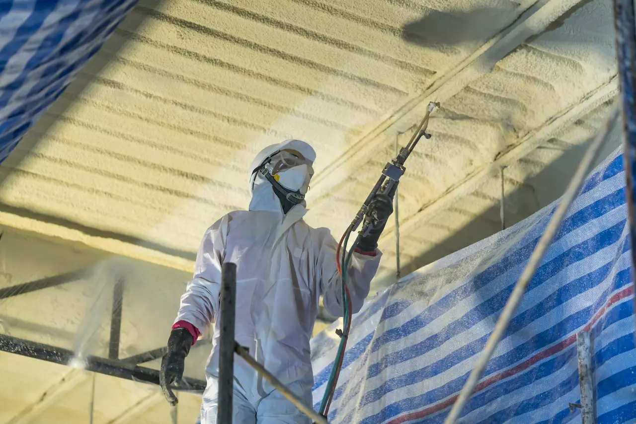 Technician spraying foam insulation.