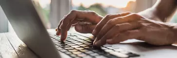 Person working on laptop closeup.