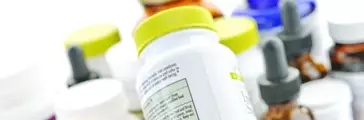 Hand holding medicine bottle to read label